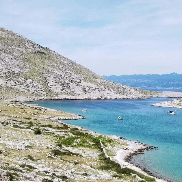A bay on Krk with turquoise water below bare hills